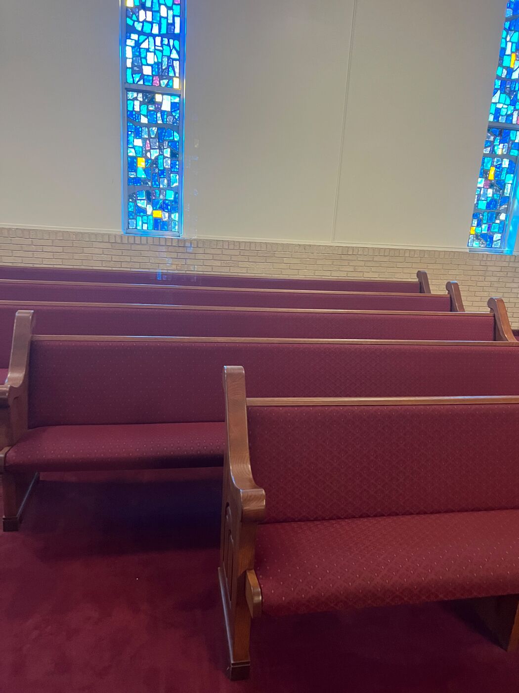 Church pews beneath stained glass windows